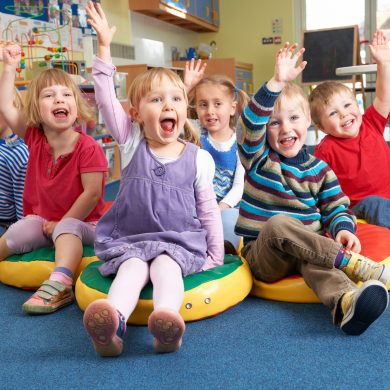 Group Of Pre School Children Answering Question In Classroom Group Of Pre School Children Answering Question In Classroom